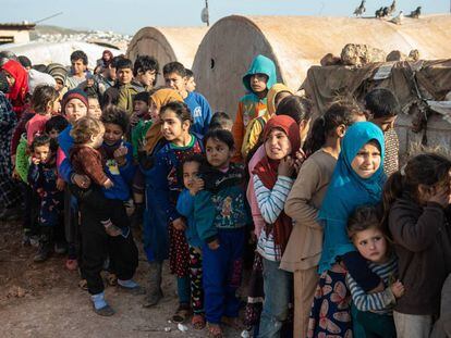 Niños refugiados sirios hacen cola para recibir alimentos en un campamento en la provincia de Idlib.