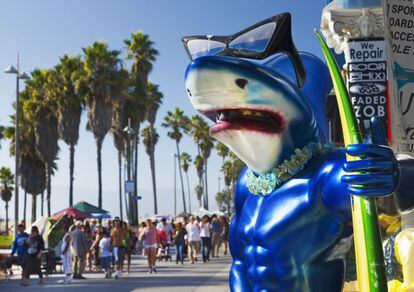 Un tiburón surfero entre el paisanaje de Venice Beach, en Los Ángeles (California).