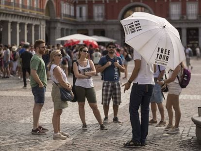 Un grupo de turistas escucha a un guía de un free tour en la plaza Mayor.  