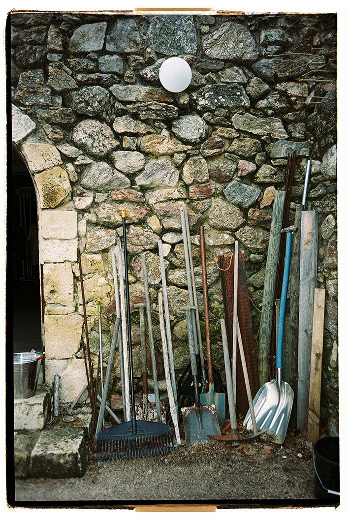 Utensilios de jardinería sobre un muro medieval.
