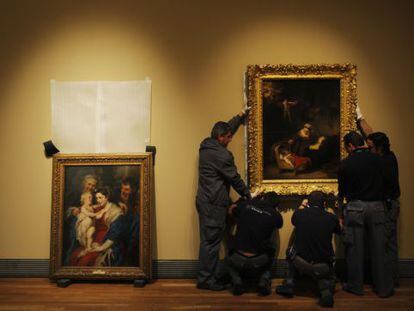 Un grupo de operarios en la exposición de El Prado 'Rembrandt, pintor de historias'.