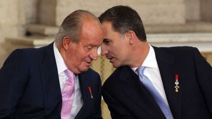 Juan Carlos I con su hijo, Felipe VI, el 18 de junio de 2014, en el acto de sanción de la ley de abdicación en el palacio Real.