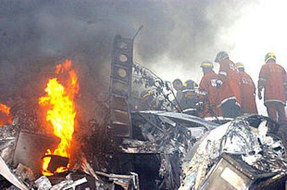 Los bomberos examinan los restos del Boeing 767-200 chino que se estrelló en Corea del Sur.