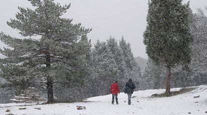 Dos excursionistas disfrutan de la primera nieve caída en las inmediaciones de Sant Joan de Penyagolosa, en Castellón, ayer.