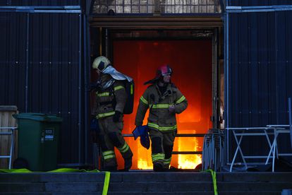 本周二，几名消防员在火灾期间离开哥本哈根证券交易所的主入口。 