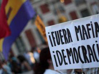 Detalle de una pancarta durante la manifestación que varios centenares de personas han llevado a cabo hoy en la capital, bajo el lema "Fuera mafia, hola democracia", convocados por el movimiento 15M,  para denunciar que políticos y banqueros, a los que consideran "la élite corrupta", son responsables de la actual situación de crisis.