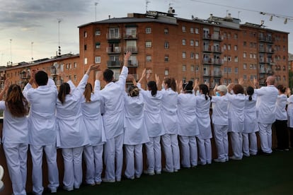 Médicos y enfermeros desde la terraza del hotel Terrassa Park (Terrassa, Barcelona), reconvertido en hospital durante la peor fase de la pandemia, aplauden y saludan a los vecinos el 18 de abril
