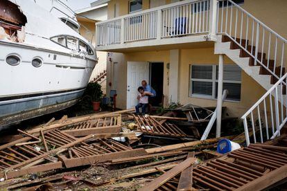 Un hombre ayuda a una mujer a salir de una casa destrozada en Fort Myers. El huracán ‘Ian’ ha dejado tras de sí un rastro de inundaciones, apagones eléctricos y daños materiales al atravesar Florida. 