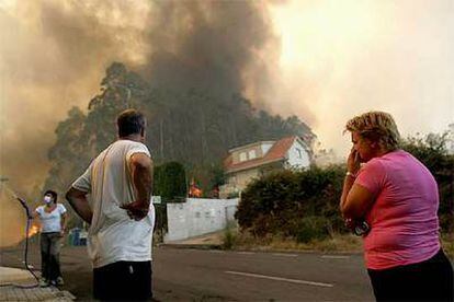 Los vecinos observan un incendio en la urbanización Aldea Nova, en el concello de Ames, A Coruña.