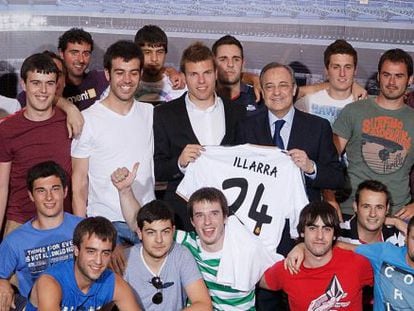 Asier Illarramendi y Florentino Pérez sostienen la nueva camiseta del centrocampista vasco, rodeados por su cuadrilla.