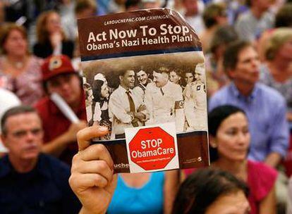 Un manifestante contra la reforma sanitaria muestra una foto de Barack Obama junto a Adolf Hitler, el martes en Reston, Virginia.