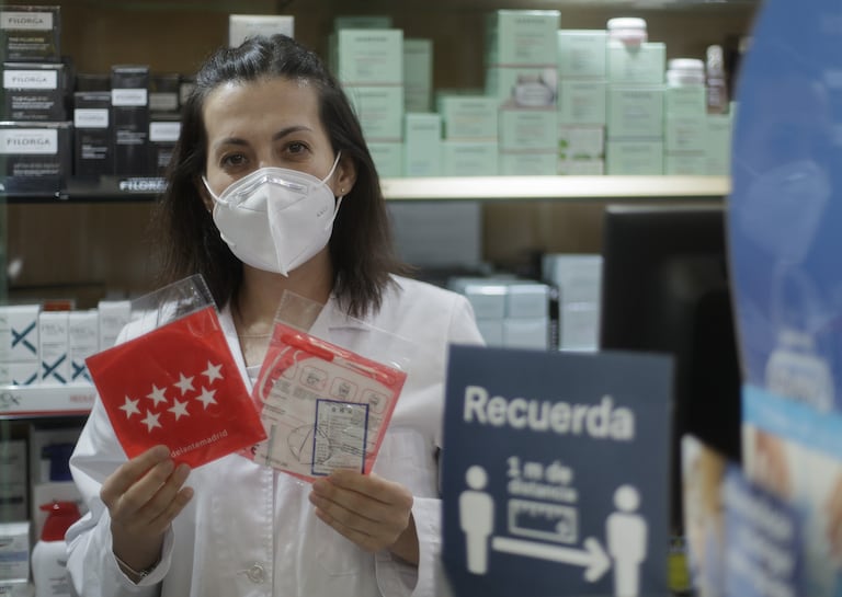 Una farmacéutica muestra una mascarilla del Gobierno regional en una farmacia de la capital.