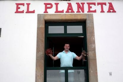 Roberto Cristóbal, one of the owners of El Planeta, holds specimens of shellfish
