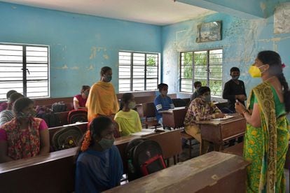 Los estudiantes de una escuela pública asisten a su clase el primer día de reapertura para los cursos de secundaria con una capacidad del 50%  después de 18 meses de cierre debido a la pandemia del coronavirus en Bangalore el 23 de agosto de 2021.