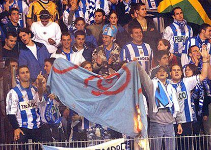 Aficionados del grupo radical Riazor Blues queman una bandera durante el partido de Copa Compostela-Deportivo.