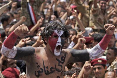 Un joven, con la cara y los brazos pintados con los colores de la bandera nacional, celebra en Saná la marcha de Saleh a Arabia Saudí.