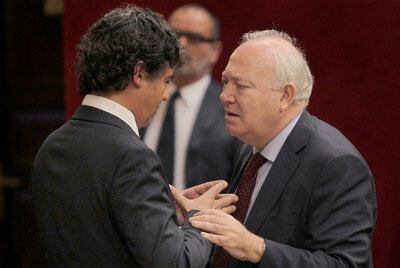 El ministro Miguel Ángel Moratinos (derecha) habla con el diputado del PP Jorge Moragas.
