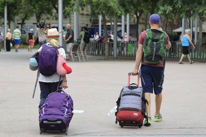 Unos turistas buscan su hospedaje en el barrio de La Barceloneta.