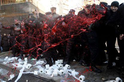 Los estudiantes arrojan pintura roja a los polic&iacute;as.
