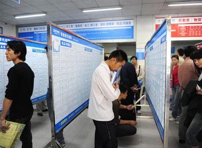 Jóvenes chinos despedidos de una fábrica buscan trabajo en una oficina de empleo de Donguan, provincia de Guandong.