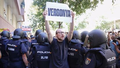 Un manifestant davant la seu de la CUP dimecres, quan la Policia Nacional va intentar requisar cartells electorals.