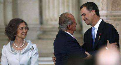 El rey Juan Carlos besa al príncipe de Asturias, Felipe de Borbón, junto a la reina Sofía, tras firmar la ley orgánica por la que se hace efectiva su abdicación, en un acto celebrado en el Salón de Columnas del Palacio Real.