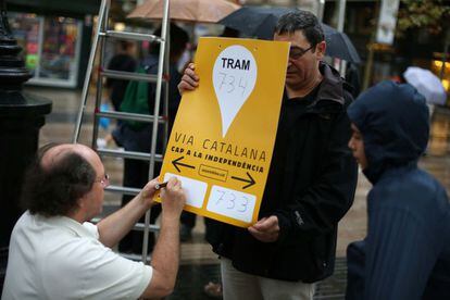 Los voluntarios de Ciutat Vella en el centro de Barcelona escriben los carteles con las indicaciones de los dos tramos de su zona.