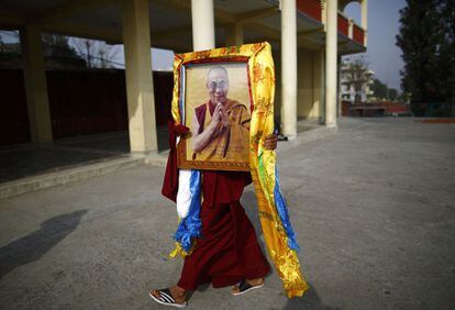 Un monje tibetano lleva un retrato del Dalai Lama, durante un acto organizado con motivo de "Losar" o el Año Nuevo Tibetano en Katmandú (Nepal).