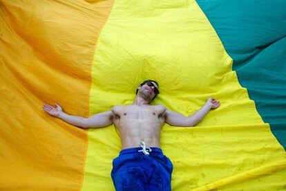 Un participante permanece tumbado sobre una bandera arcoíris durante la Gay Pride Parade en la ciudad de Lisboa (Portugal), el 17 de junio de 2017.