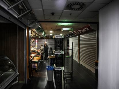 El interior del mercado de Torrijos, este lunes en Madrid, con los puestos que quedan ocupados y la parte que fue tapiada este fin de semana.