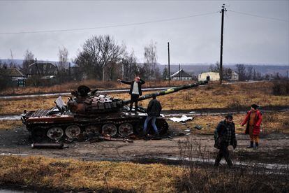 Residents of Tsupivka, in the Kharkiv region, next to the Ukrainian army tank that stayed in front of their houses after the battle to liberate the town from Russian occupation.