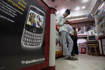 Un hombre consulta su móvil en una tienda de telefonía en la ciudad de Hyderabad, en India.