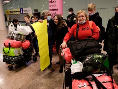 Una grupo de pasajeros ucranios, con su equipaje, en la terminal del aeropuerto de El Prat. / QUIQUE GARCÍA (EFE)