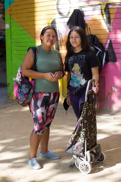 Jenifer Andrea, de 40 años, y su hija Isis, de 13, en la cola de reparto de alimentos del barrio de Aluche. 