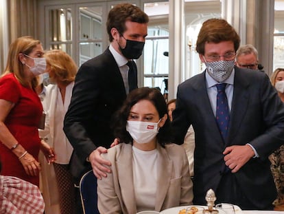 El presidente del PP, Pablo Casado, y el alcalde de Madrid, José Luis Martínez Almeida, saludan a Isabel Díaz Ayuso en un desayuno organizado por el Fórum Europa, en junio de 2021.