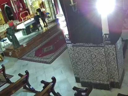 Las dos mujeres detenidas, en la iglesia de la parroquia de San Julián de Sevilla. En vídeo, las arrestadas merodean por el altar.