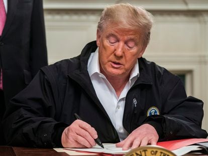 Donald Trump firma la ley de emergencia, este viernes en la Casa Blanca.
