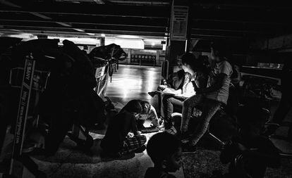 Un grupo de pasajeros en el aeropuerto de Maiquetía rellenan hojas de reclamación.