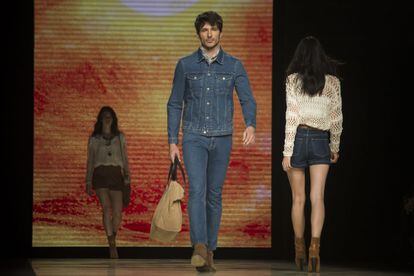 Andrés Velencoso amb pantalons i caçadora 'denim' i bossa de mà per a la primavera de Mango.