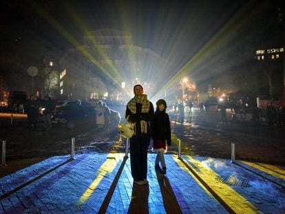 Varios ciudadanos ucranios contemplan la iglesia de Andriivska iluminada por el artista suizo Gerry Hofstetter, en Kiev, el pasado 23 de diciembre.