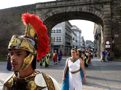 Un centuri&oacute;n durante la celebraci&oacute;n de Arde Lucus, con la muralla romana, patrimonio mundial, de fondo.