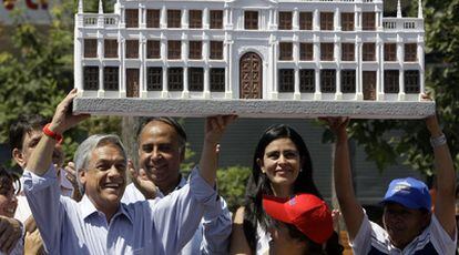 Sebastián Piñera sostiene una réplica del palacio de La Moneda.