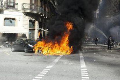 Un coche y diversos contenedores arden en la confluencia de las calles Diputación y Balmes de Barcelona.