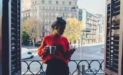 Una mujer toma un café junto a la ventana.