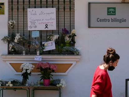 Una mujer pasa este jueves junto a las flores en recuerdo del alumno fallecido en el instituto Sierra de Mijas (Málaga).