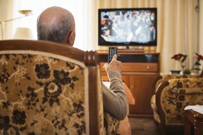 Un hombre mayor viendo la televisión.