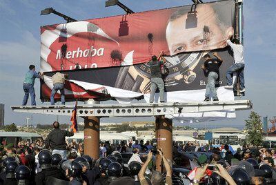 PROTESTA ARMENIA CONTRA ERDOGAN EN LÍBANO. El recuerdo de las matanzas de armenios por las tropas otomanas durante la I Guerra Mundial planeó ayer sobre la visita a Líbano de Recep Tayyip Erdogan. Un grupo de libaneses armenios arranca un cartel del primer ministro turco en Beirut.
