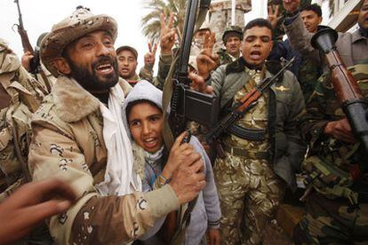 Jóvenes y exsoldados de Gadafi celebran ayer la liberación de Bengasi en un cuartel de la ciudad.