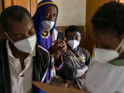 La voluntaria de la Cruz Roja sudafricana, Marrieth Ndlela, toma los datos del migrante de origen congoleño John Nsombo para apuntarlo al programa Tracing the Faces, que consiste en difundir fotos de personas que están buscando a sus seres queridos para intentar reunirlos. En Pretoria, Sudáfrica, el 18 de diciembre de 2020.