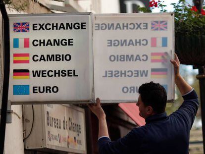 Un trabajador coloca un cartel de cambio de moneda en Gibraltar.